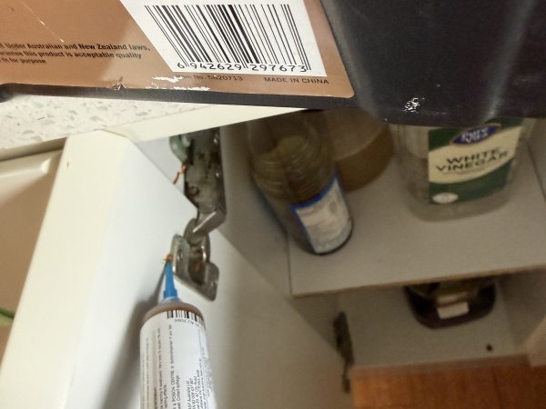 Cockroach gel baiting applied under a kitchen cupboard hinge point