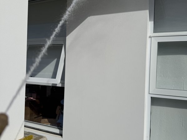 Exterior wall being spray treated for spiders and general pests